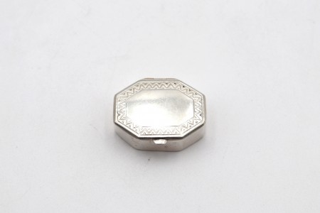 Caixa de comprimidos em prata lisa com gravados geométricos na tampa